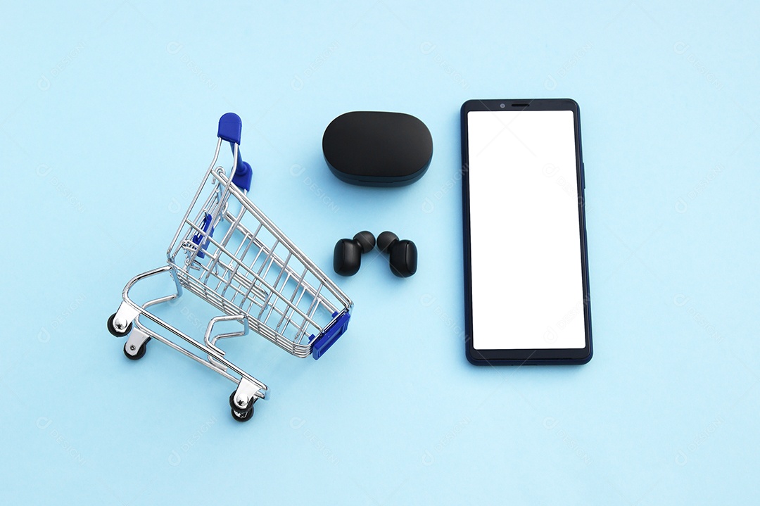 Carrinho de compras com um smartphone e fones de ouvido sem fio pretos sobre fundo azul