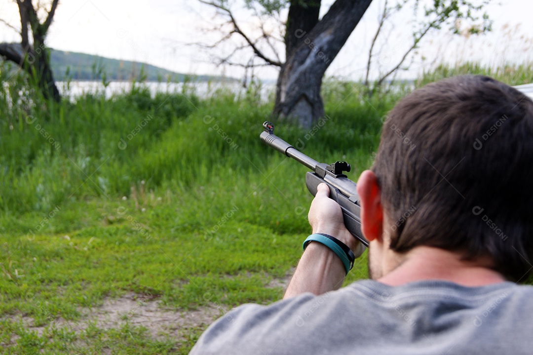 Homem atirando e vista para um lago