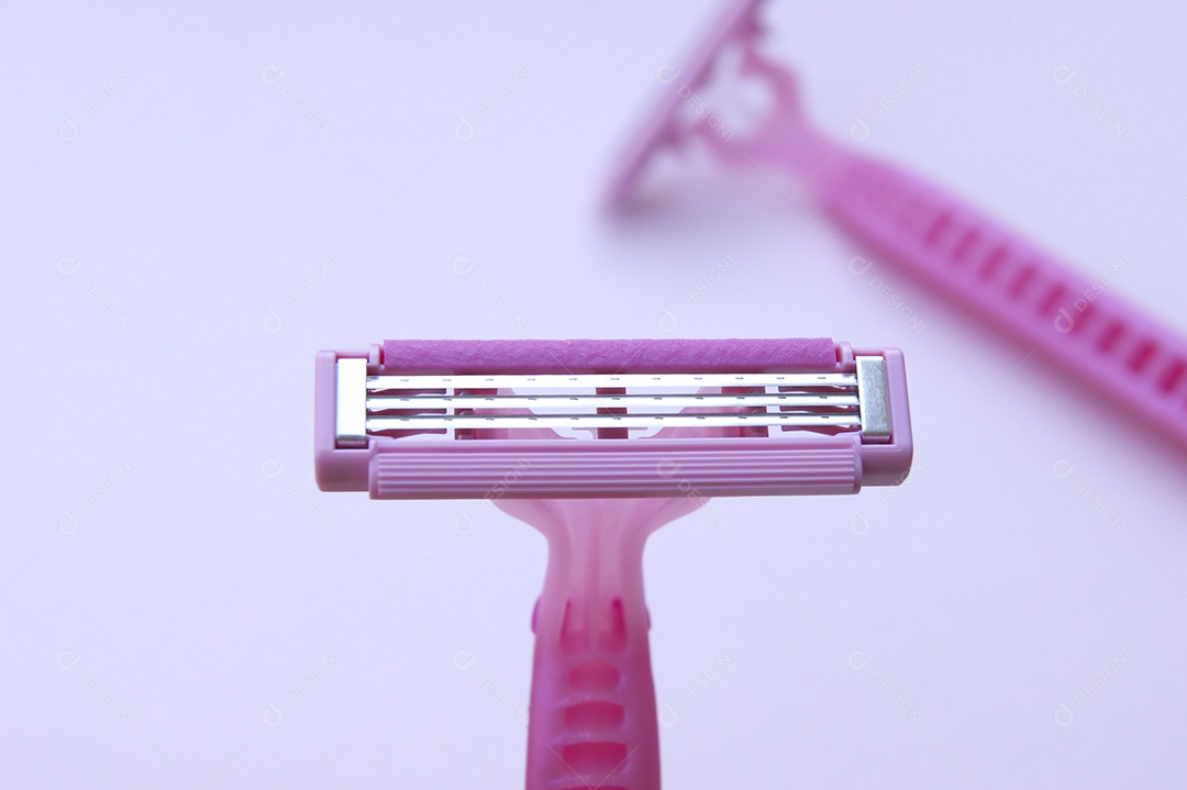 Gilete barbeador rosa sobre fundo claro