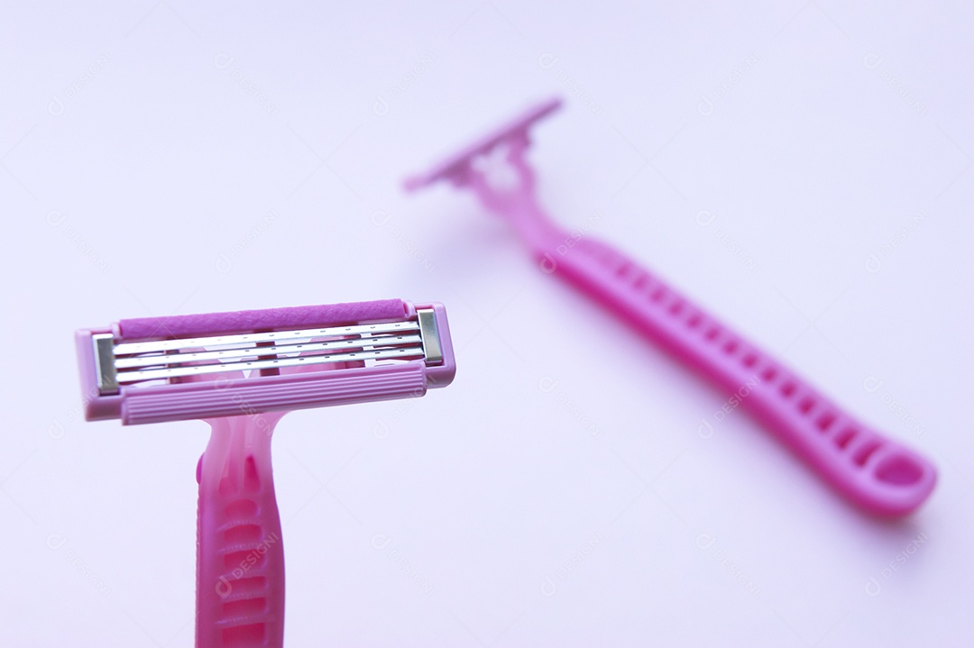 Gilete barbeador rosa sobre fundo claro