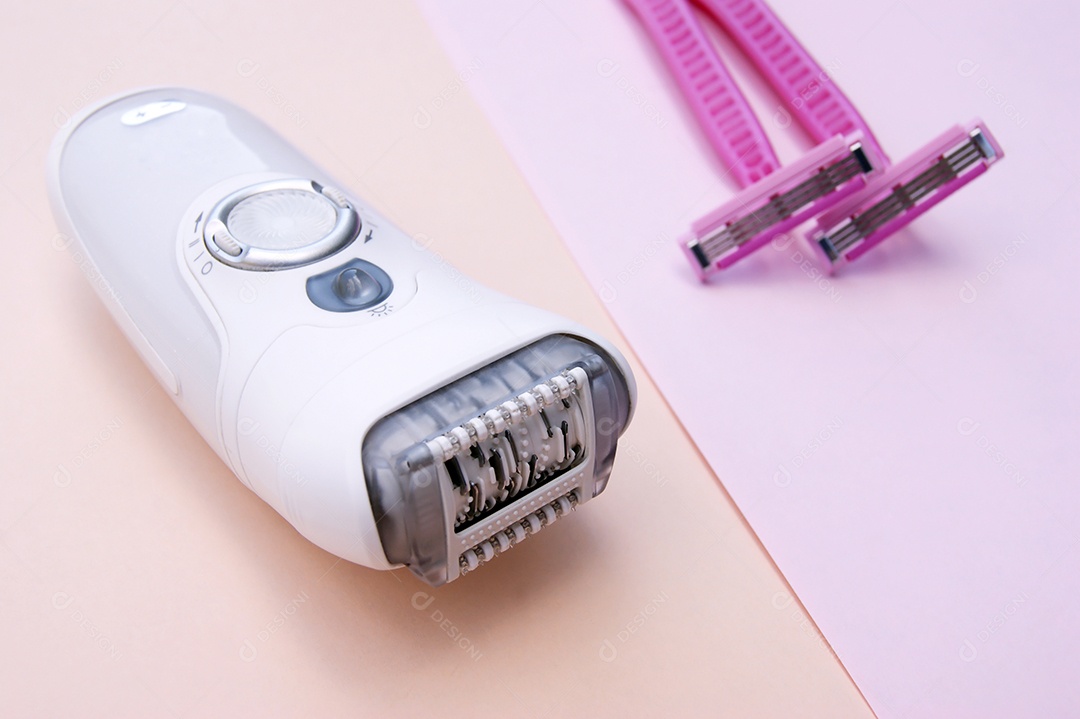 Depilador branco e navalha rosa em um fundo rosa