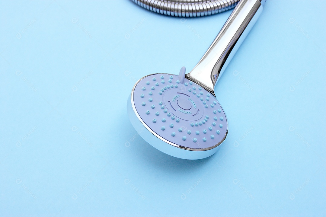 Chuveiro azul com mangueira de metal sobre fundo azul