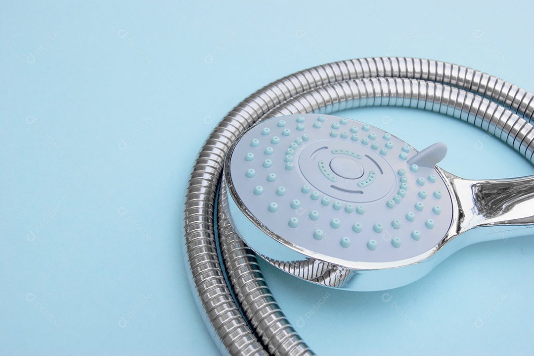 Chuveiro azul e mangueira de metal sobre fundo azul