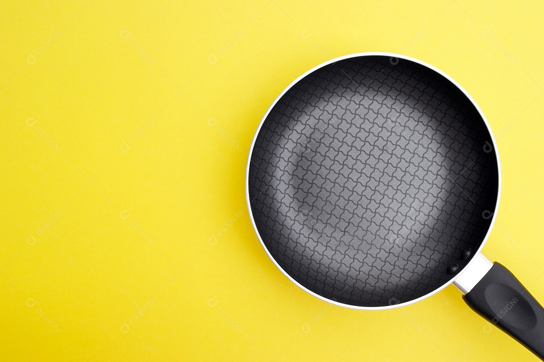 Uma frigideira antiaderente sobre um fundo amarelo brilhante