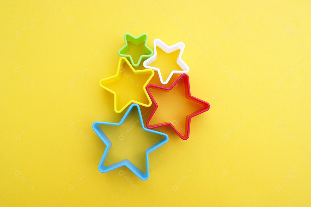 Cinco formas coloridas de estrelas em fundo amarelo