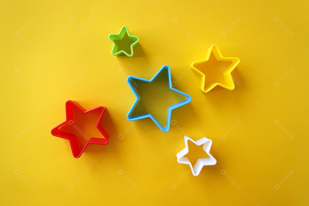 Formas de estrela coloridas sobre fundo amarelo