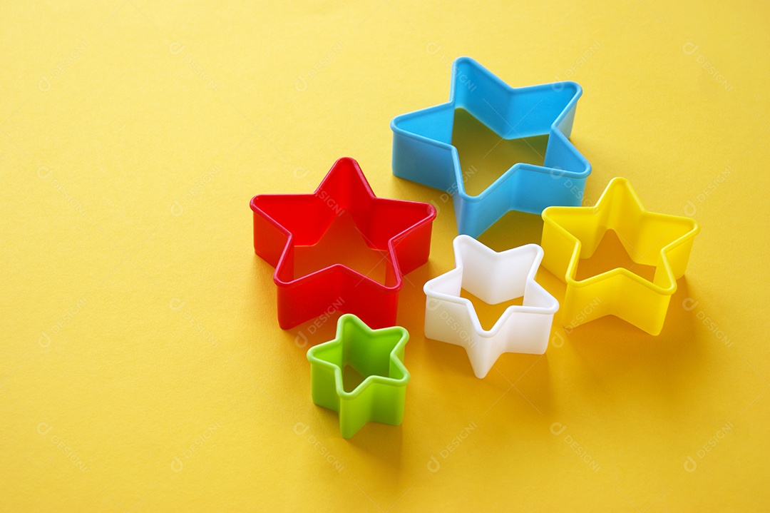 Formas coloridas em formato de estrela colorida sobre fundo amarelo