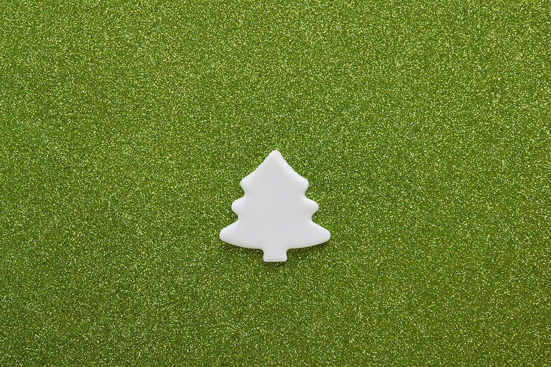 Mini árvore de enfeite feita de aroeira sobre fundo verde