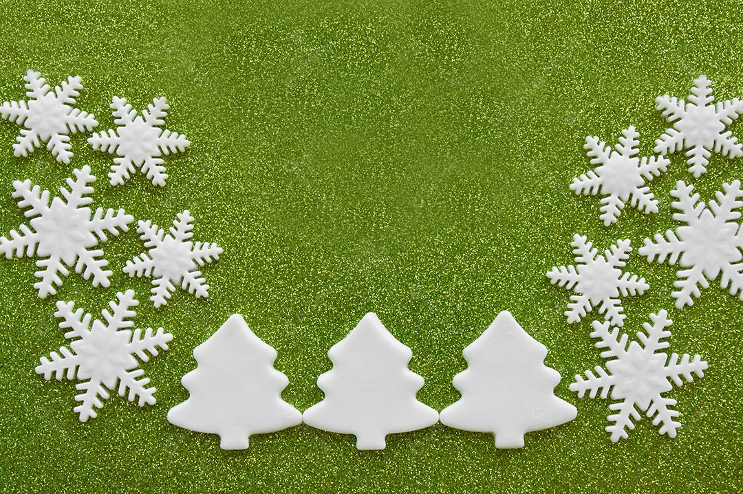 Árvores de Natal esculpidas brancas e flocos de neve de aroeira sobre fundo verde