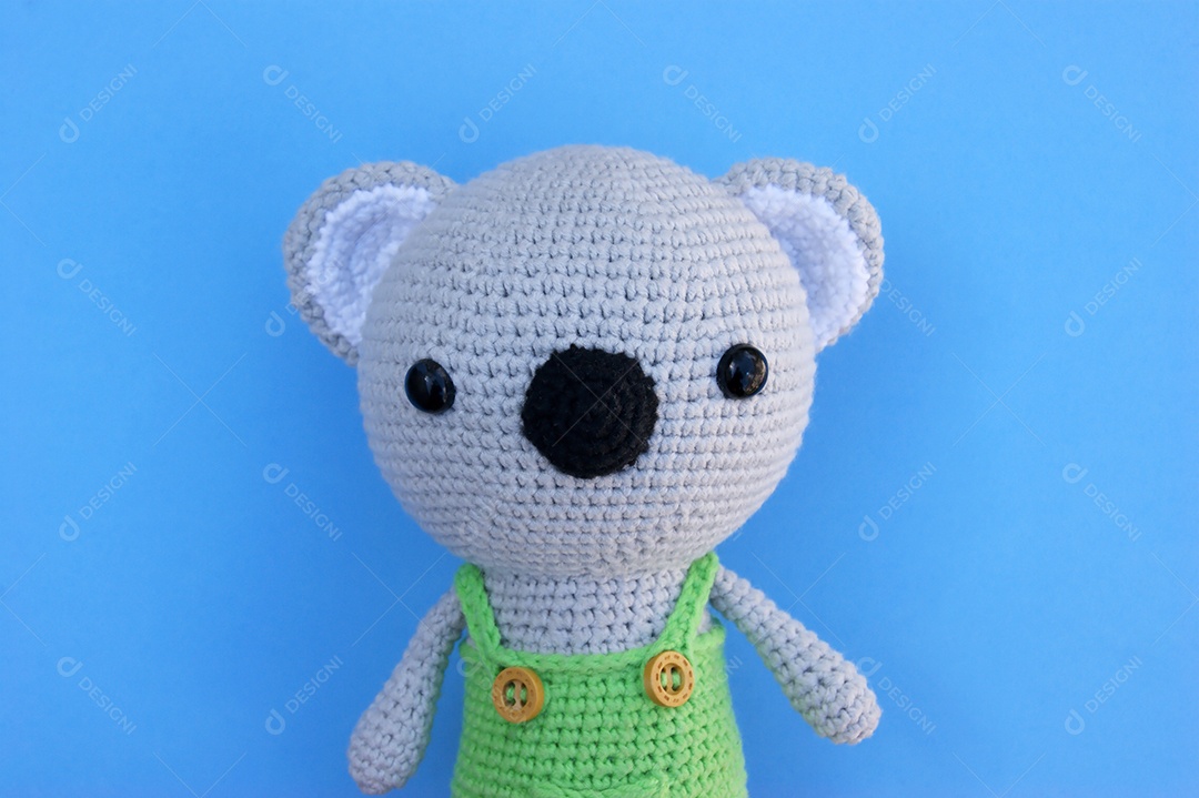 Ursinho de crochê sobre fundo azul