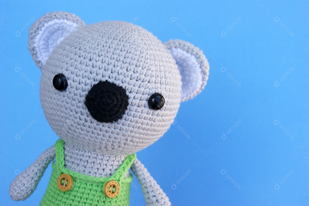 Ursinho de crochê sobre fundo azul