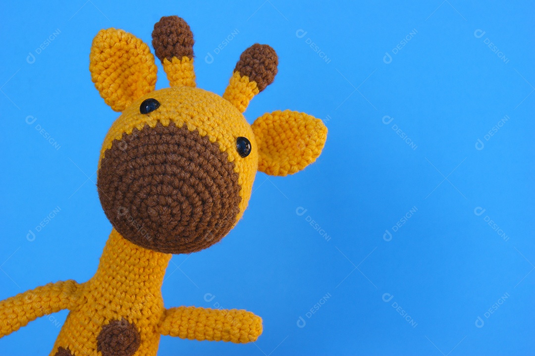 Girafa amarela de crochê macia sobre fundo azul