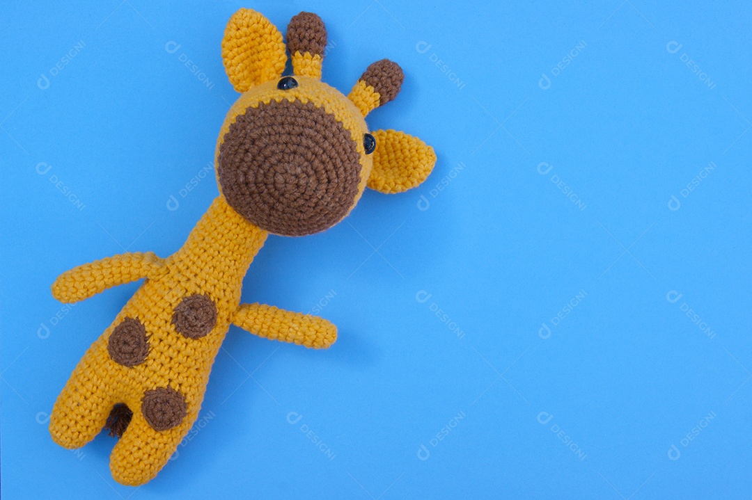 Girafa amarela de malha macia sobre fundo azul