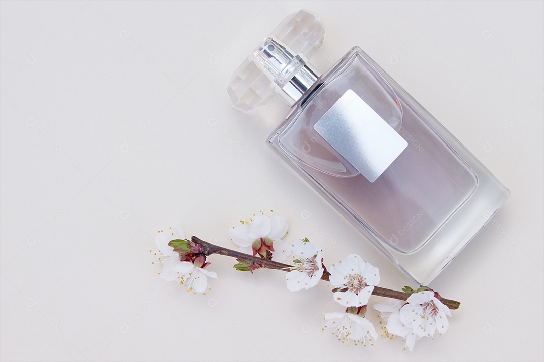 Frasco de perfume com flores ao lado