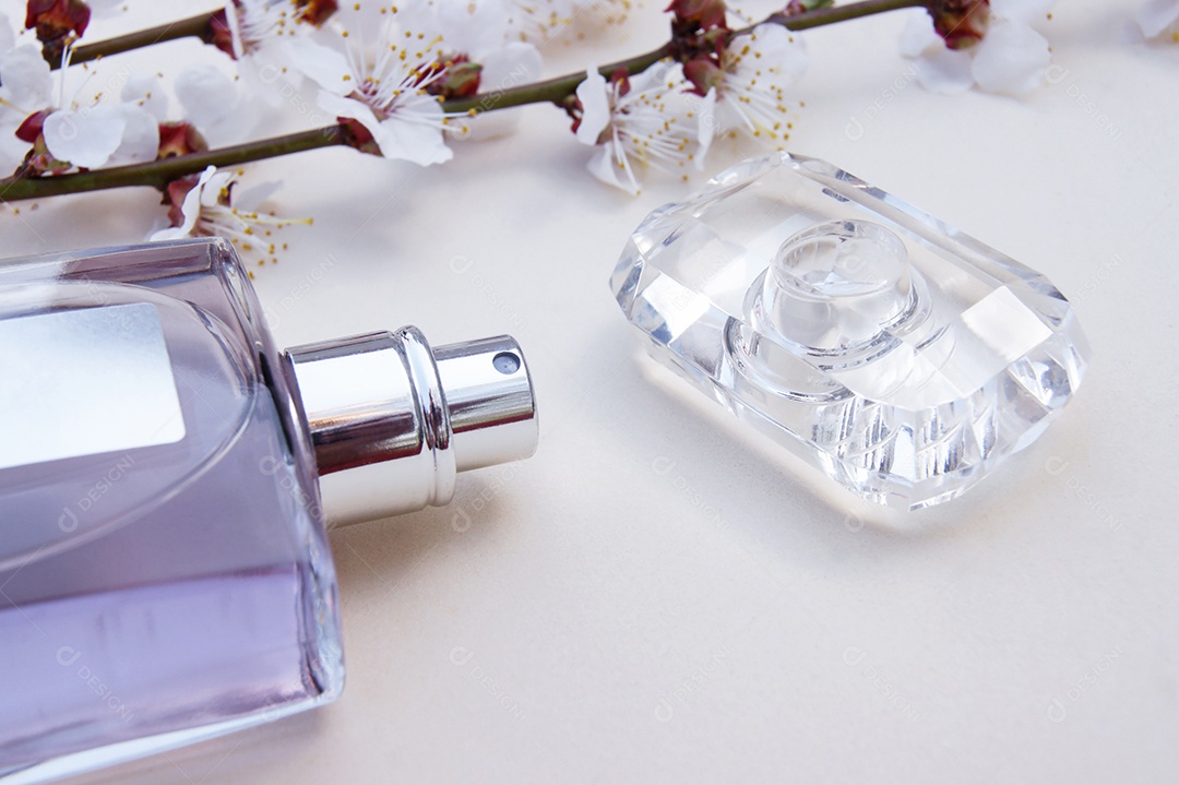 Flor e perfume com tampa ao lado sobre fundo branco