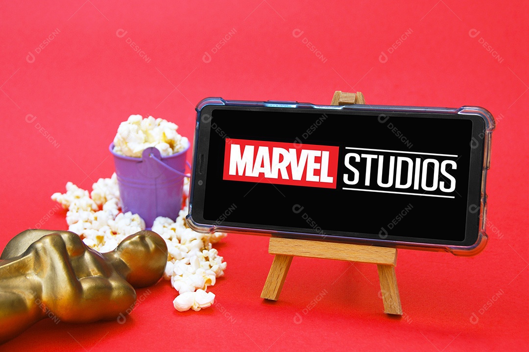 Celular com logotipo Marvel Studios pipoca e troféu conceito de premiação cinematográfica