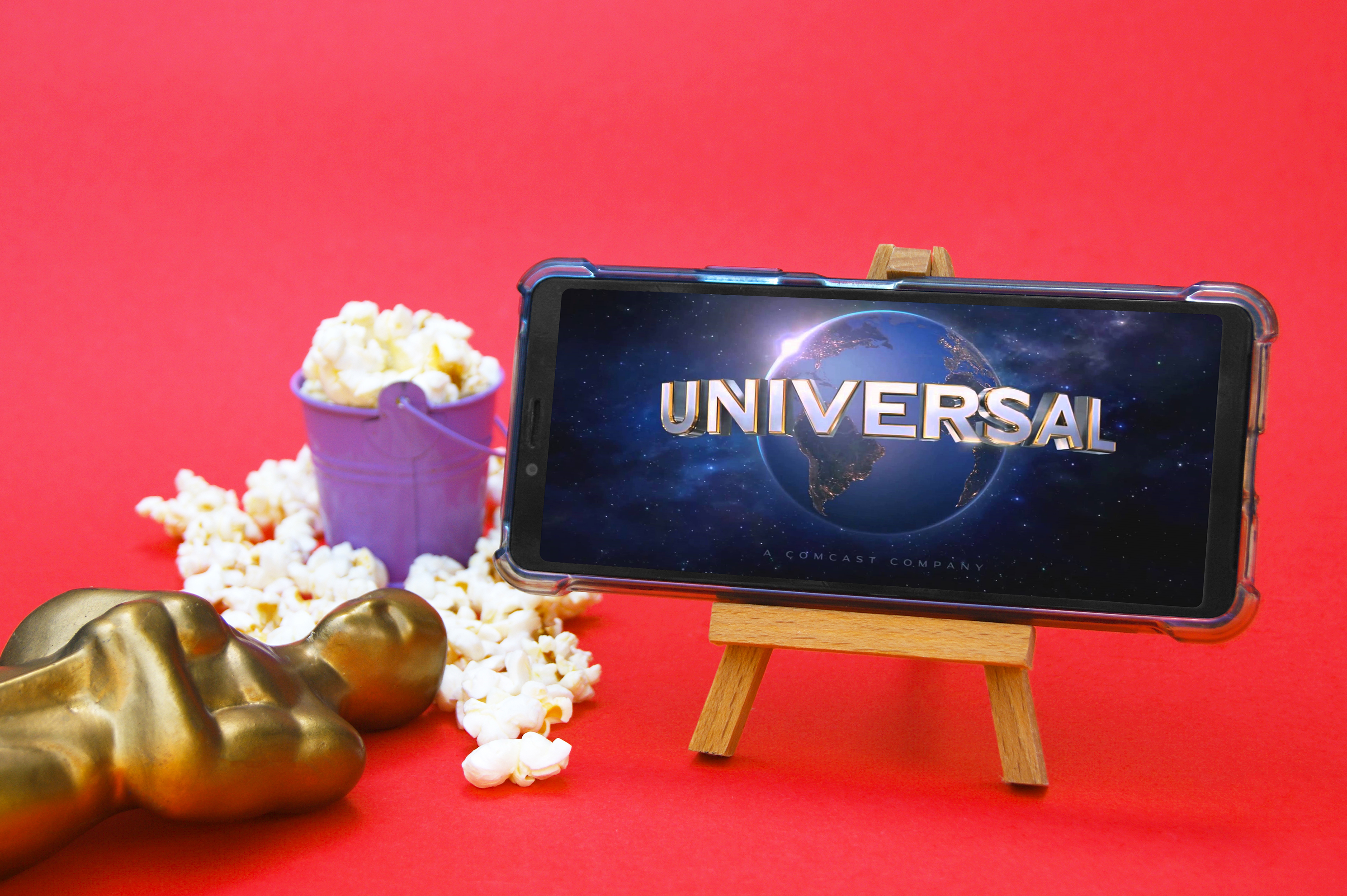 Celular com logotipo Universal pipoca e troféu conceito de premiação