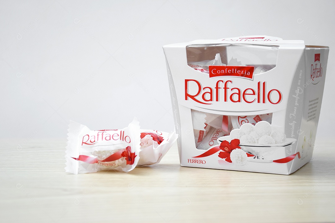 Caixa Raffaello sobre uma mesa de madeira clara e fundo branco