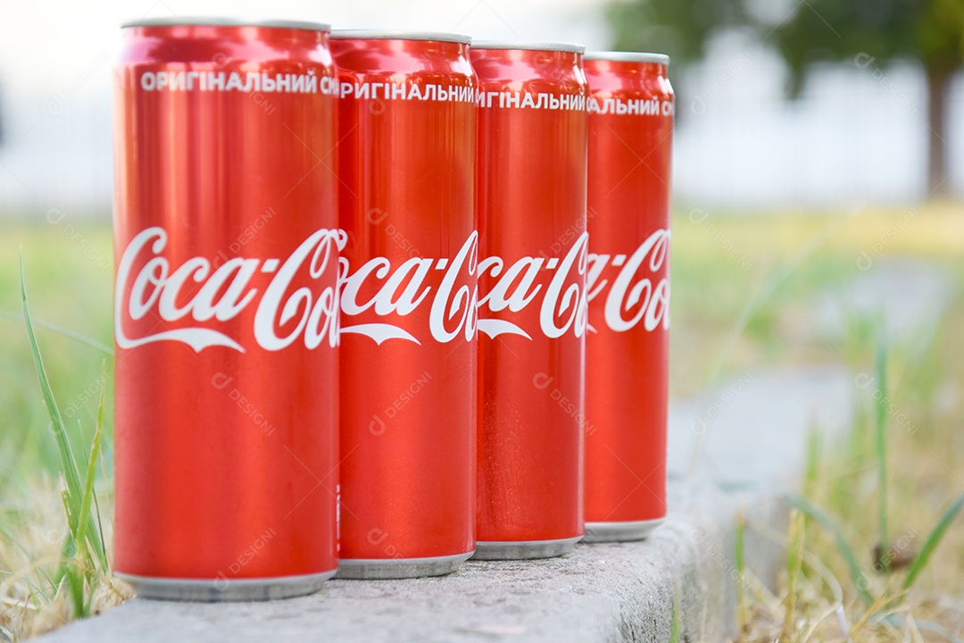 Latas de coca cola sobre meio fio