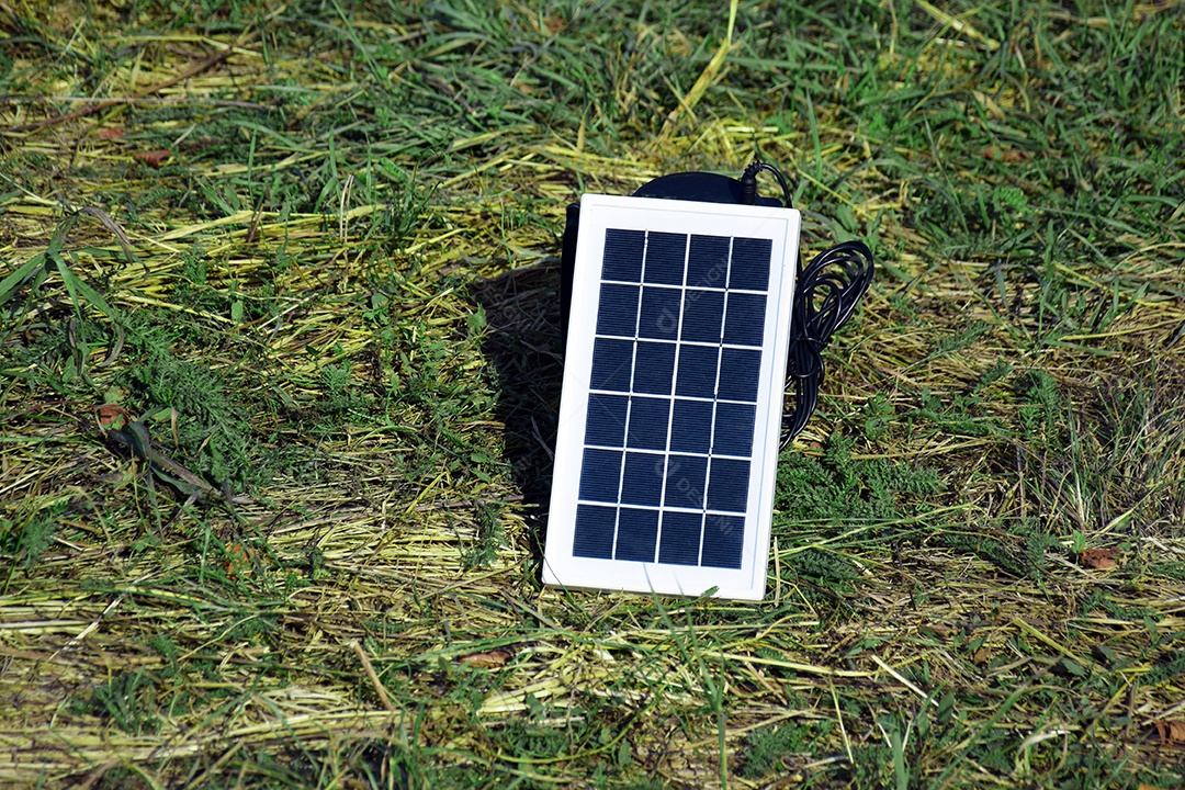 Bateria solar pequena carregando sobre um gramado