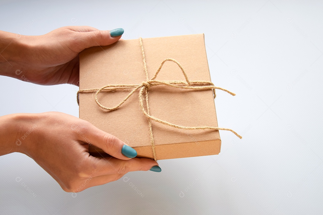 Caixa de presente artesanal e mãos segurando