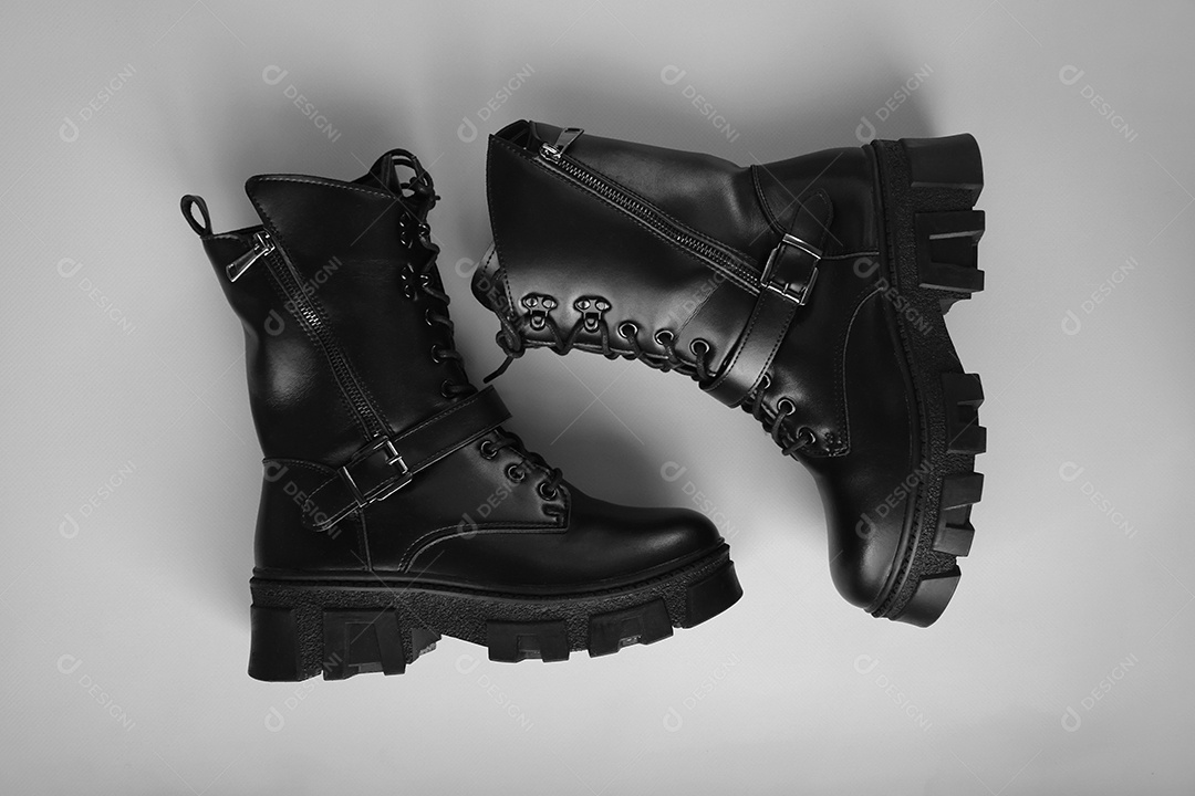Botas preta de couro sobre fundo cinza