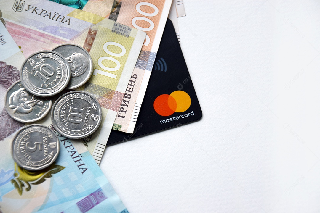 Moedas dinheiro ucraniano e cartão de crédito sobre fundo branco