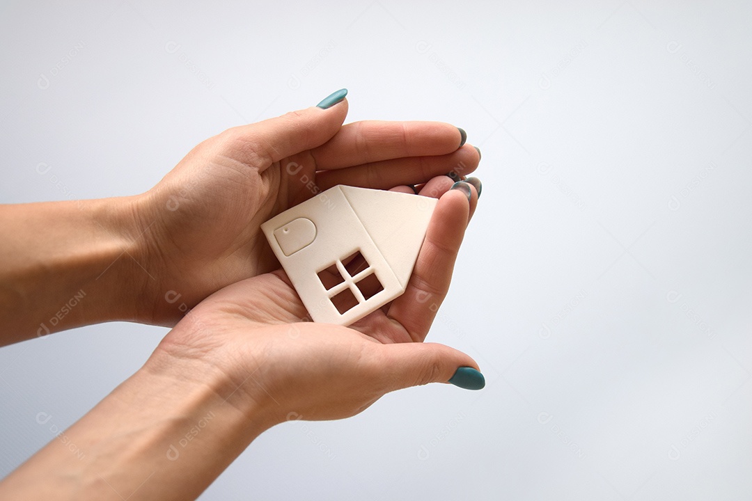 Mãos segurando casinha de papel
