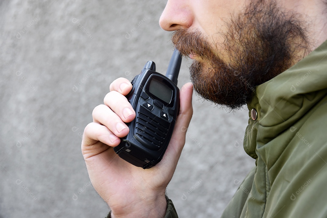 Homem se comunicando em radio walkie-talkie