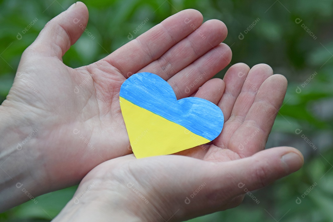 Mulher tem nas mãos coração decorado com cor da bandeira Ucrânia