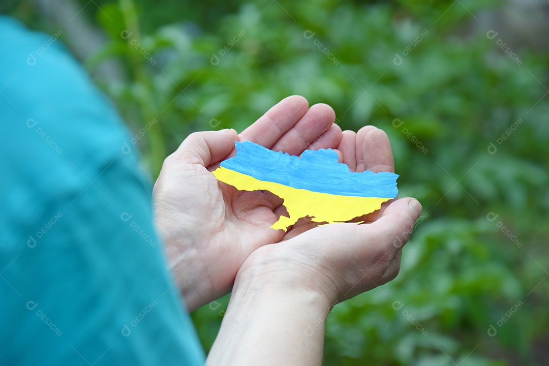 Mulher tem nas mãos o contorno do país Ucrânia decorado