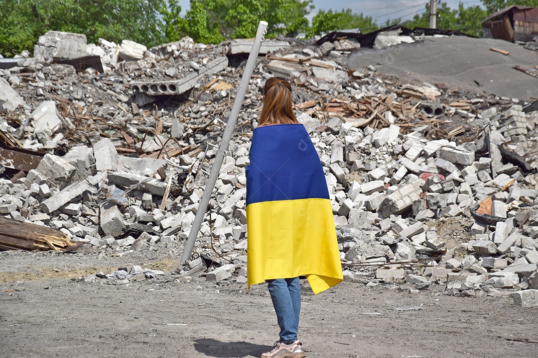 Bandeira da ucrânia em costas vendo destroços da guerra