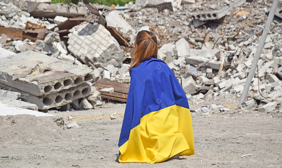 Mulher vendo destruição com bandeira nas costas