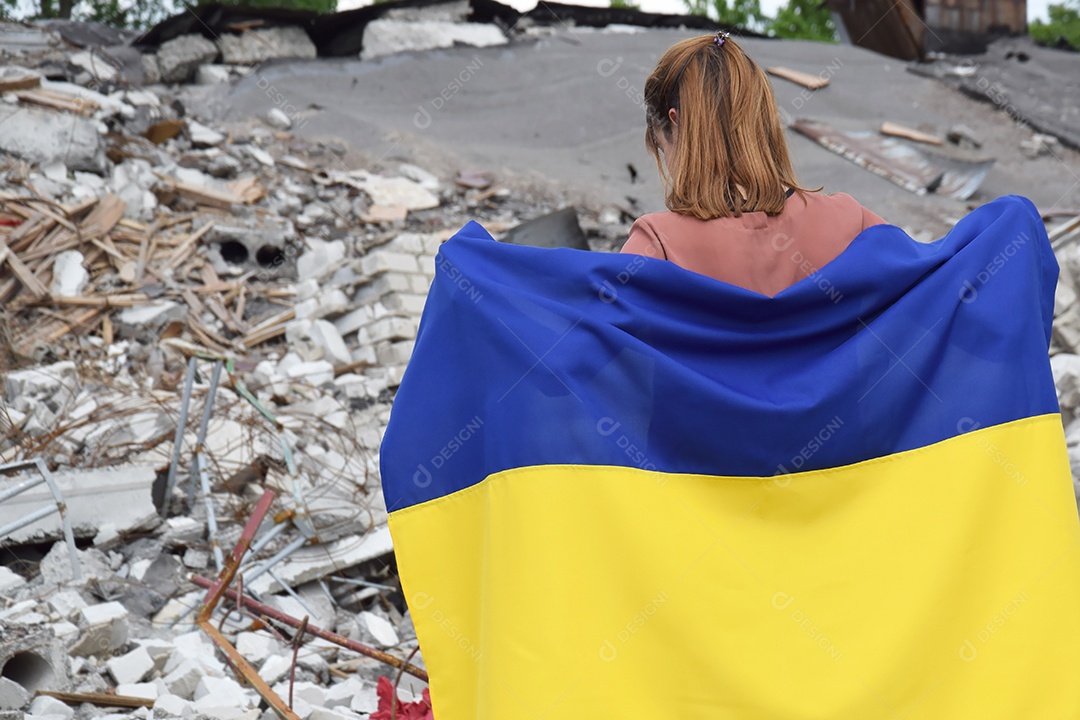 Mulher segurando bandeira em meio a destruição de guerra