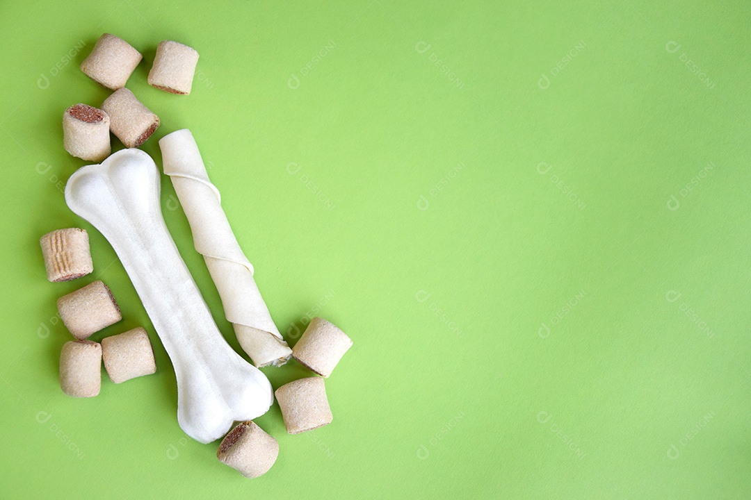 Guloseimas para cães sobre fundo verde claro