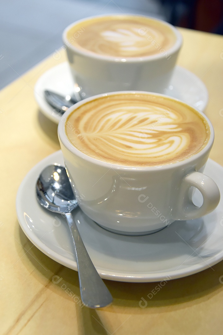 Xícaras de porcelana com cappuccino dentro sobre uma mesa