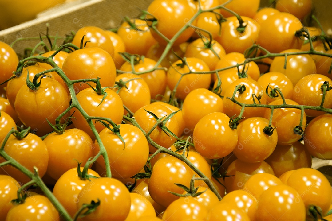 Tomates amarelos em bancada de supermercado