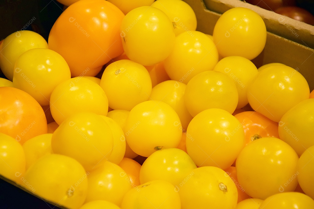 Tomates amarelos em bancada de supermercado