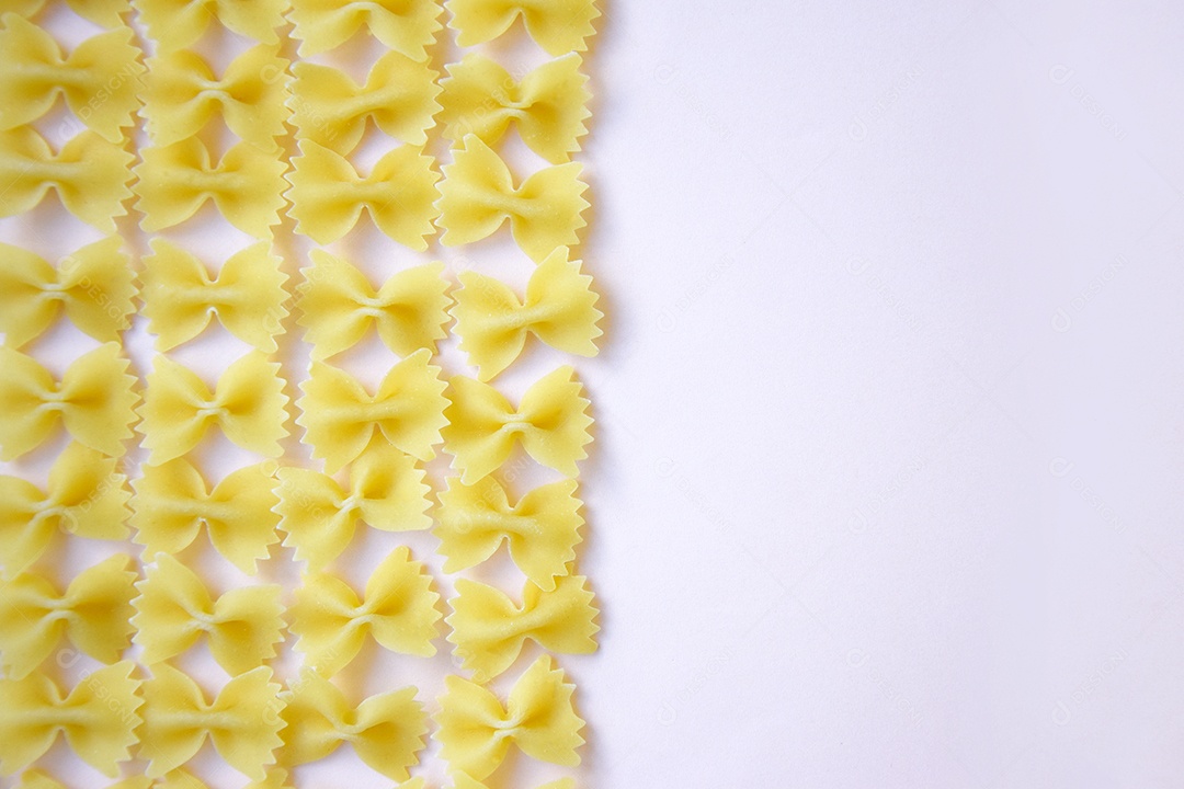 Macarrão borboleta em fila sobre mesa branca