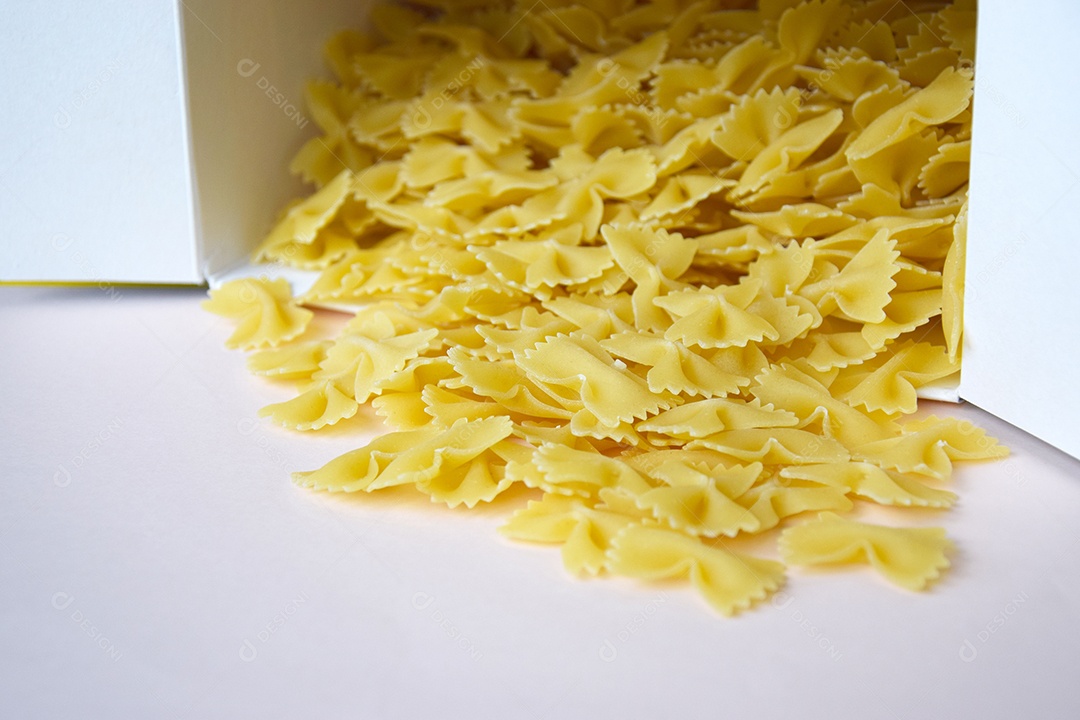 Massa em forma de borboleta despejada da caixa sobre a mesa