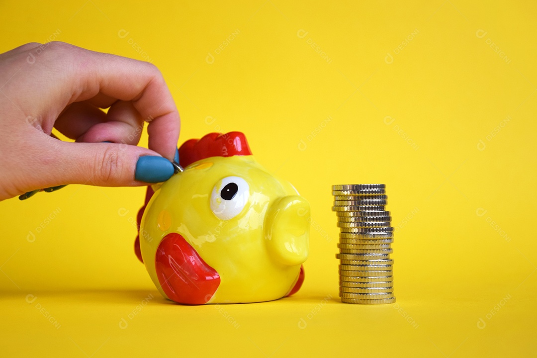 Cofre de peixe com muitas moedas sobre fundo amarelo