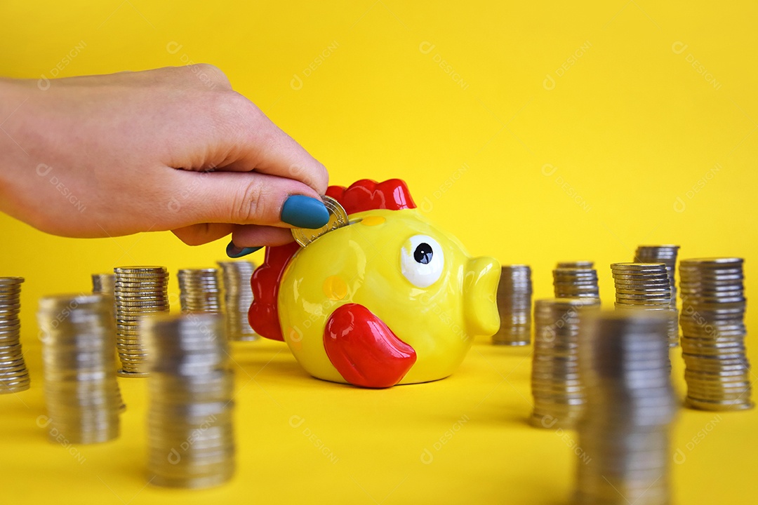 Muitas moedas empilhadas e mulher colocando dentro do cofre