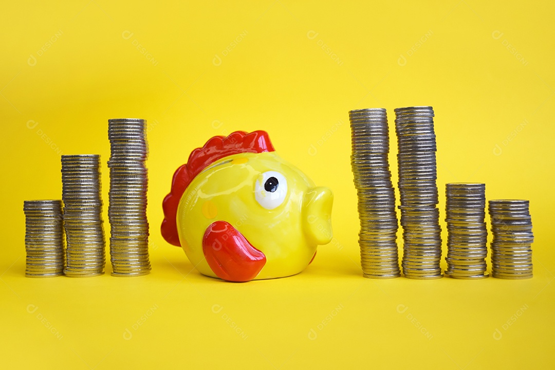 Cofre de peixe amarelo com pilhas de moeda ao lado