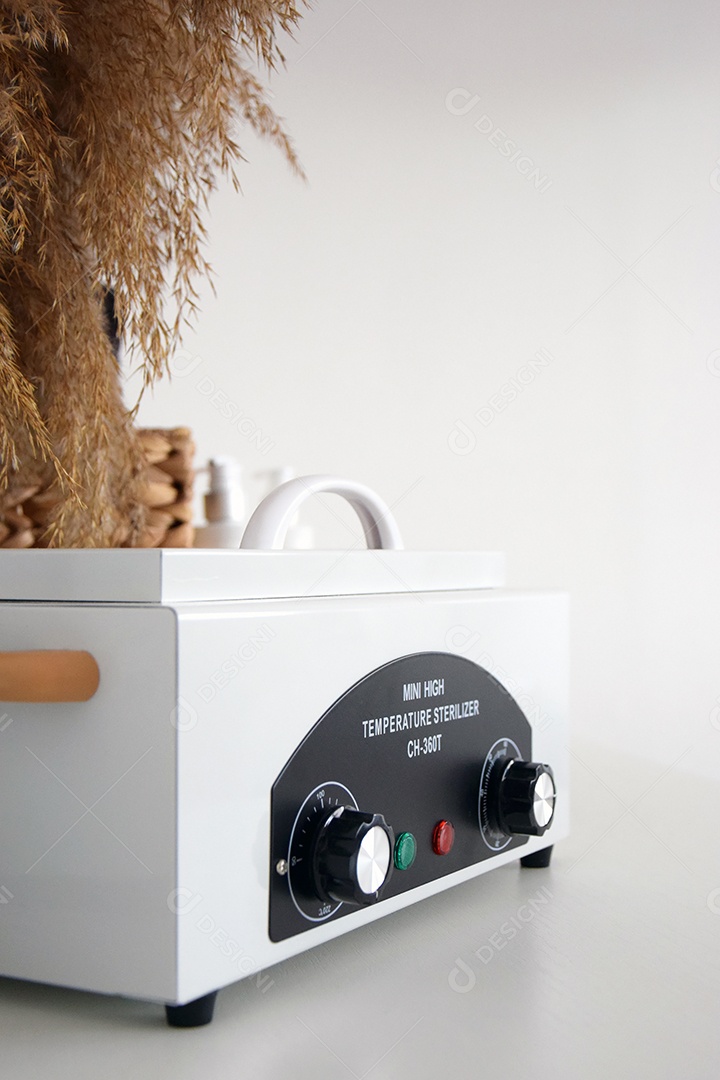 Pequeno esterilizador de alta temperatura a vapor sobre mesa branca