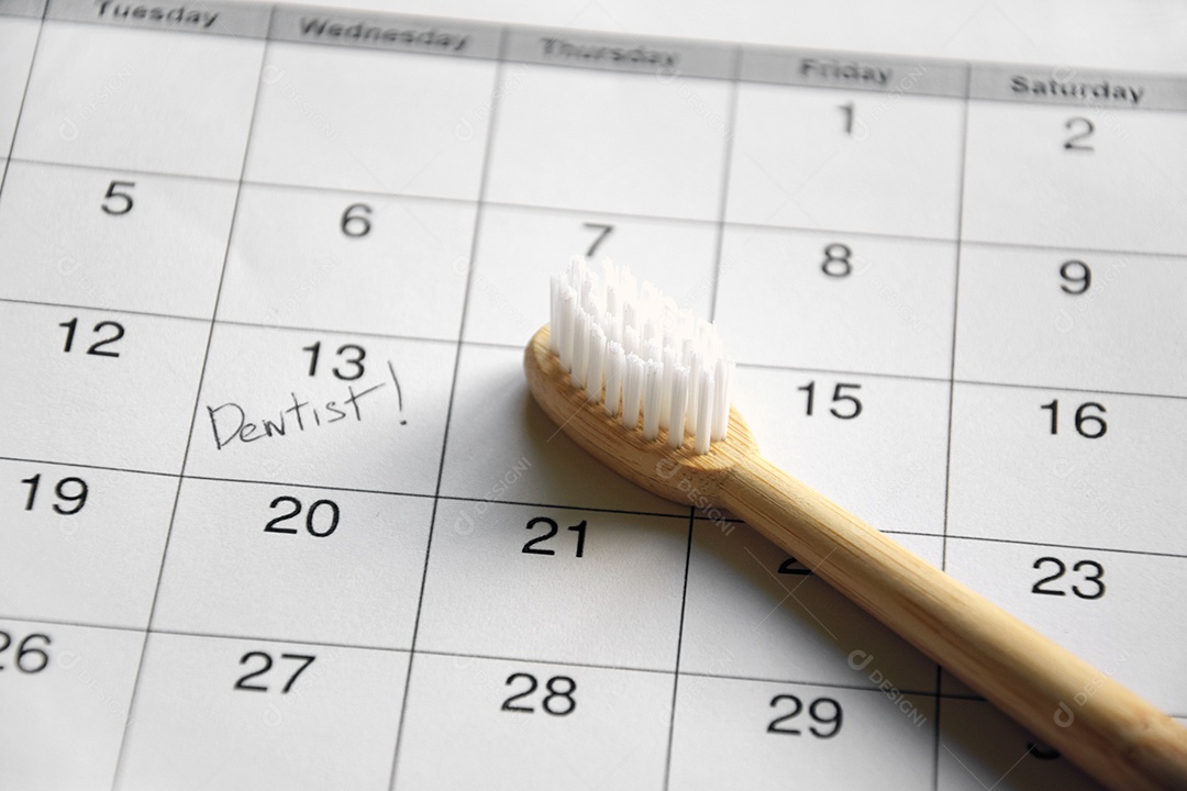 Escova em cima de calendário com data para o dentista