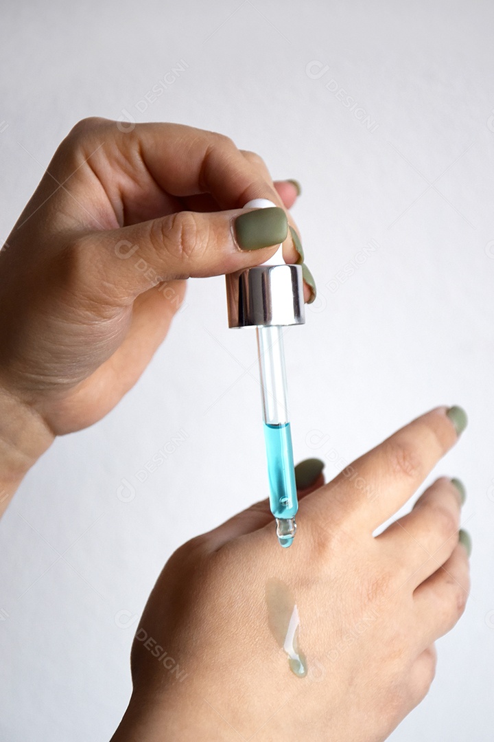 Mulher com pipeta pingando óleo sobre fundo branco