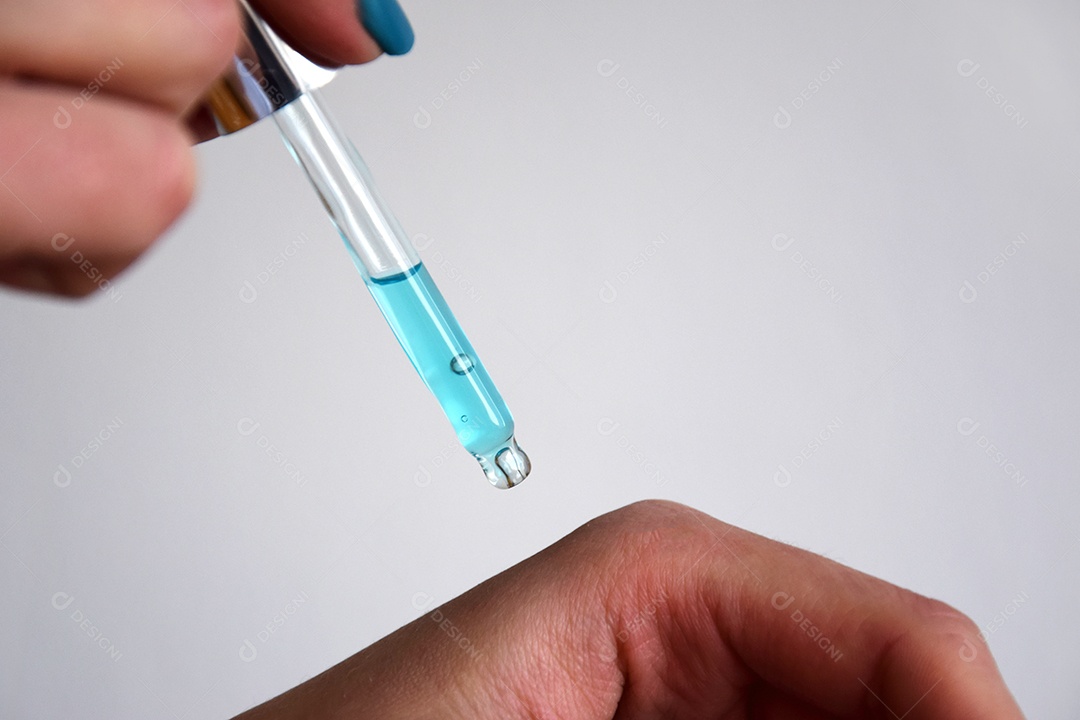 Mulher pingando óleo nas mãos com pipeta de vidro