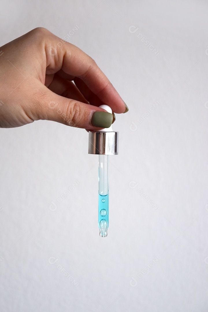 Mulher com pipeta pingando óleo sobre fundo branco