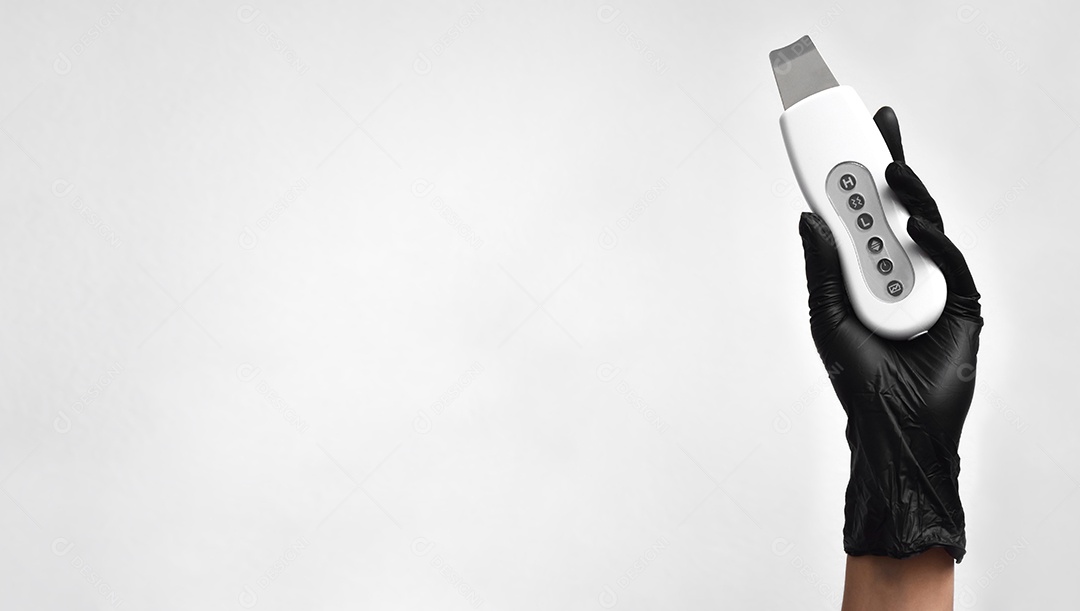 Nas mão feminina um esfoliante ultrassónico