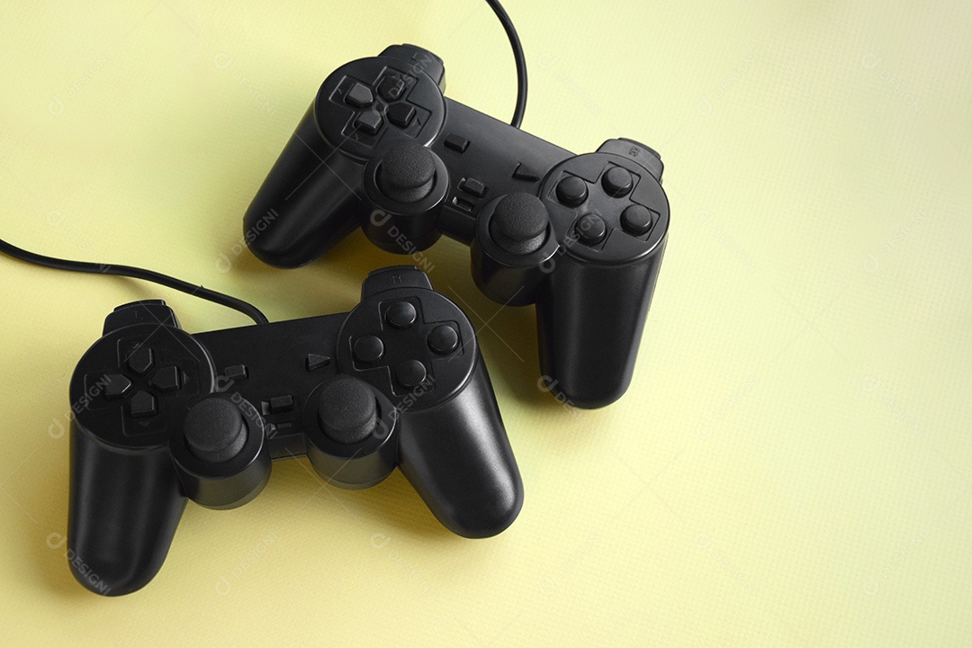 Controles de videogame preto sobre fundo amarelo